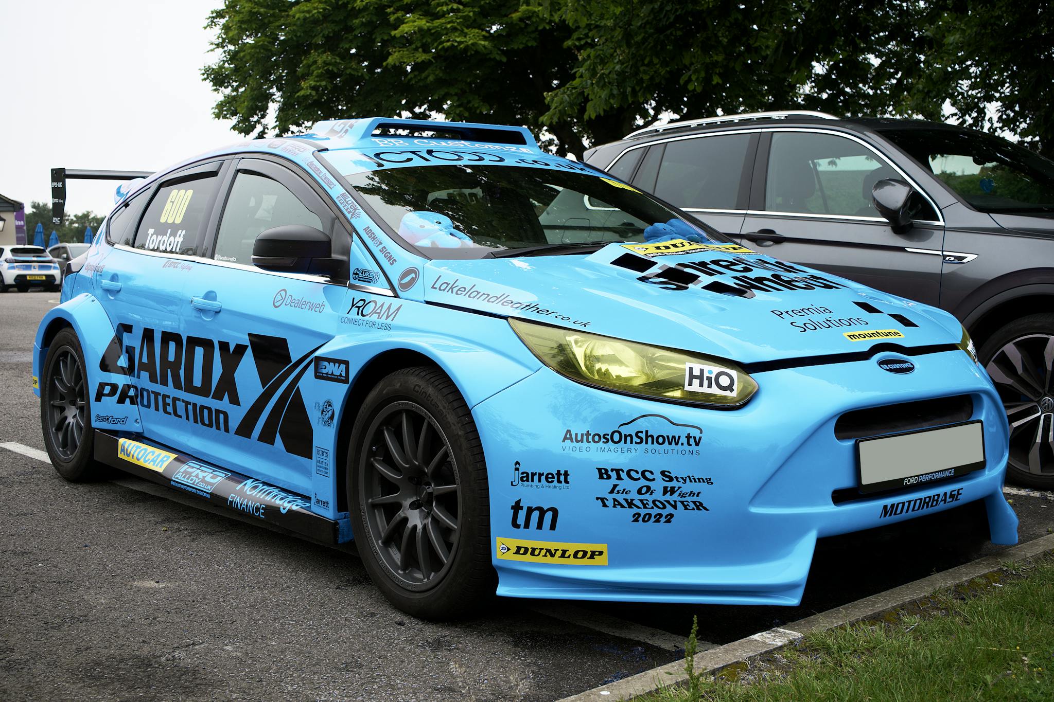 Bright blue sports car with sponsorship decals parked in Whitstable, England.